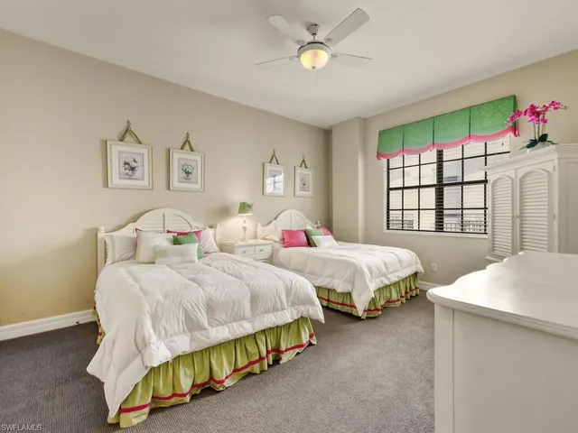 a bedroom with two beds and a window