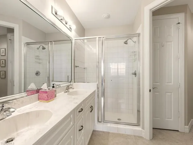 a bathroom with a double vanity sink mirror and shower