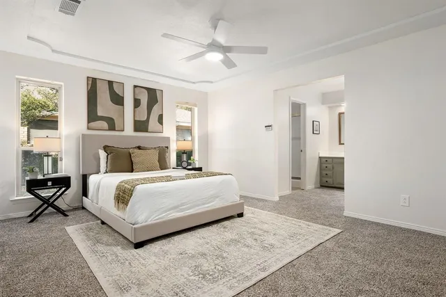 a bedroom with a large bed and a chandelier fan