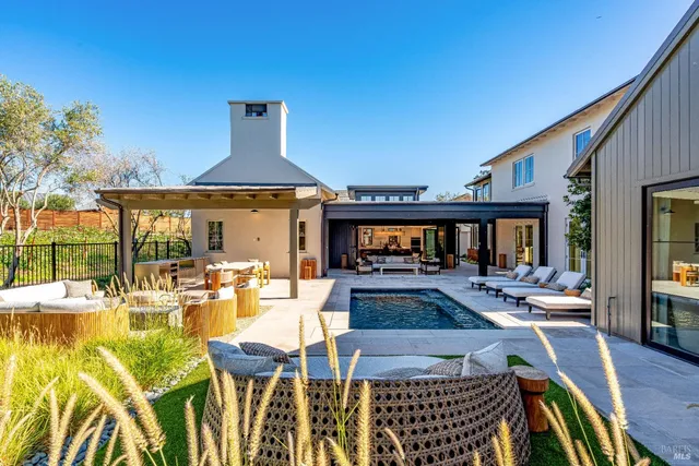 a view of a house with pool and chairs