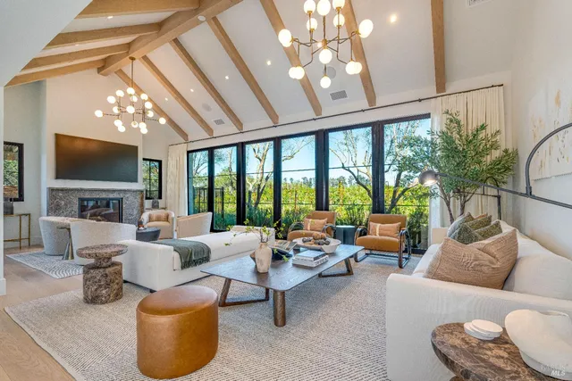 a living room with furniture a flat screen tv and a large window