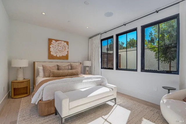 a spacious bedroom with a large bed and a chandelier