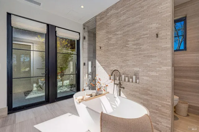 a spacious bedroom with a bed and large windows