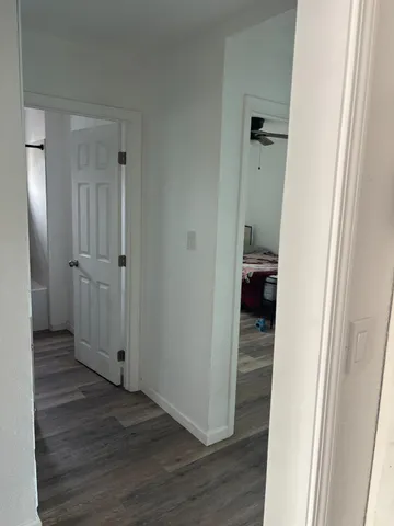 a view of a hallway with wooden floor