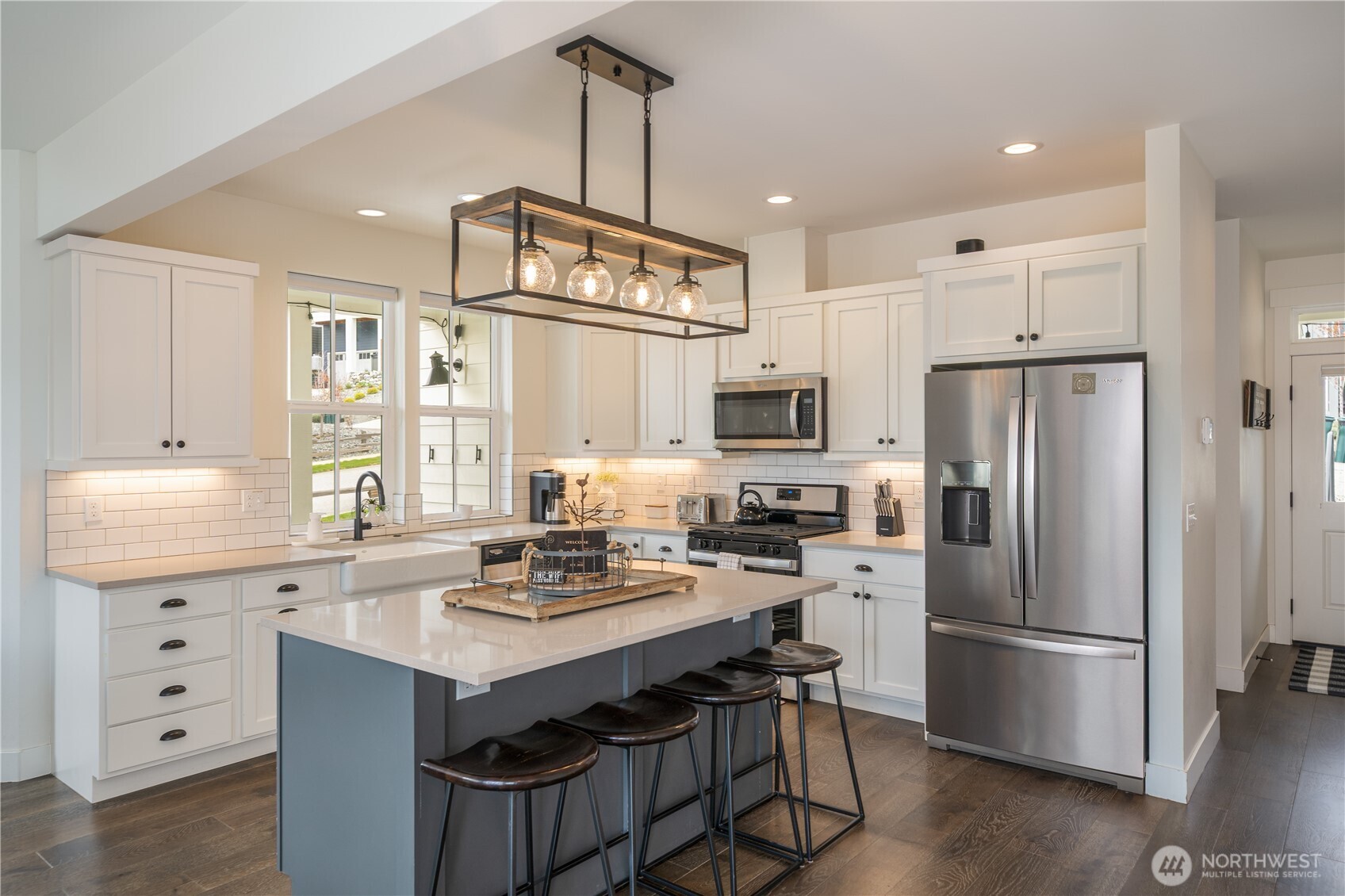 187 Bobcat Lane Chelan, WA 98816 - Photo 6 of 40 a kitchen with a refrigerator a sink dishwasher a stove a refrigerator and white cabinets with wooden floor