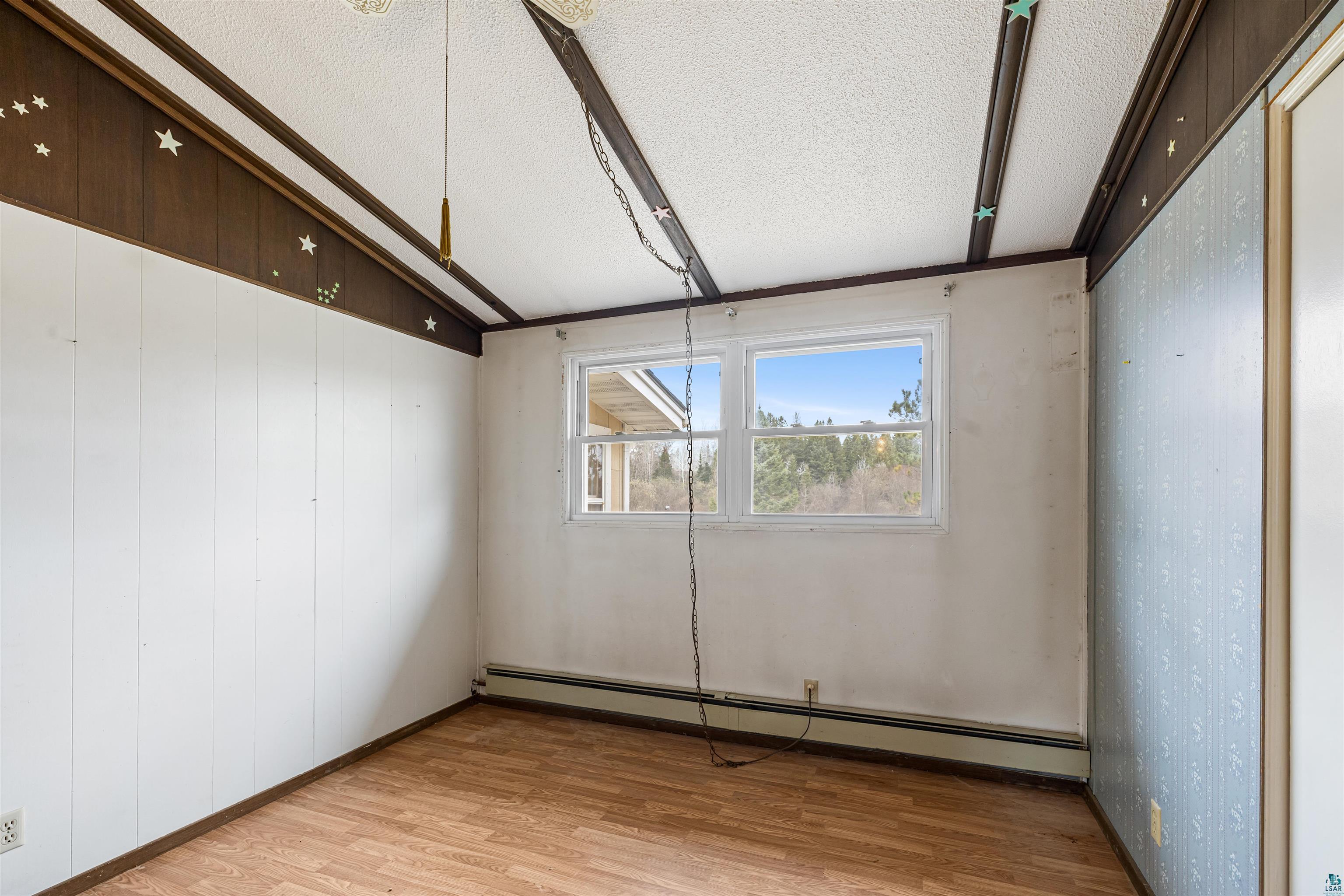 11574 Town Line Road Hibbing, MN 55746 - Photo 16 of 41 Room featuring wood-finish flooring, two windows, and a white paneled wall