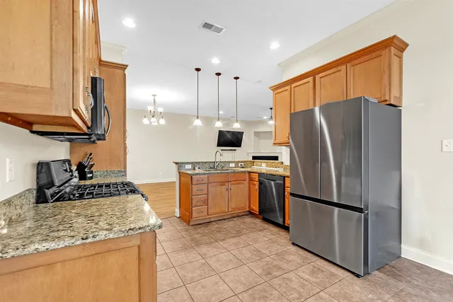a kitchen with stainless steel appliances granite countertop a refrigerator stove top oven and sink