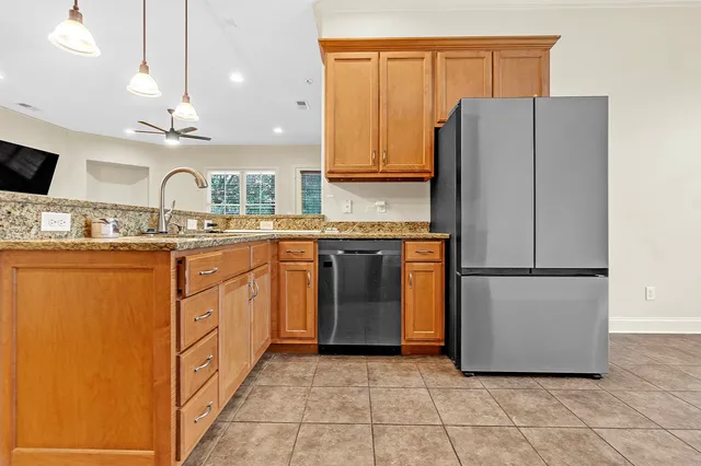 a kitchen with stainless steel appliances granite countertop a refrigerator a sink a stove and white cabinets