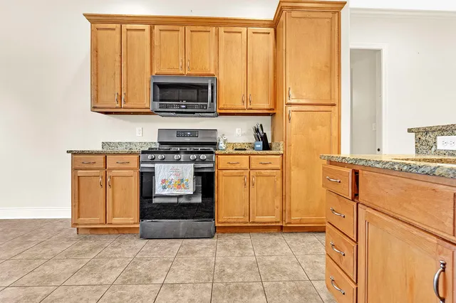 a kitchen with stainless steel appliances granite countertop a stove a sink and a microwave