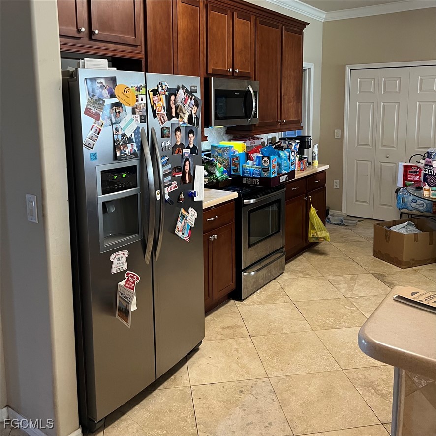 2702 Nature Pointe Loop Fort Myers, FL 33905 - Photo 13 of 25 a kitchen with a refrigerator and a stove