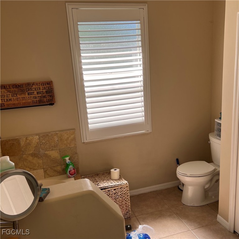 2702 Nature Pointe Loop Fort Myers, FL 33905 - Photo 18 of 25 a bathroom with a toilet a sink and a window