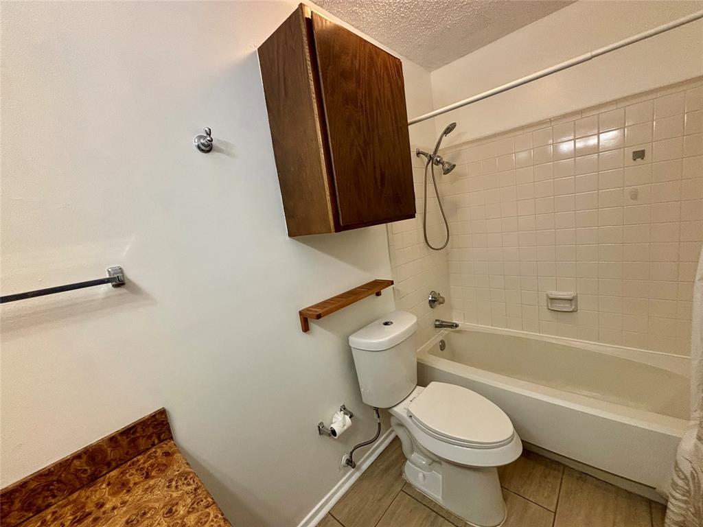 12480 Abrams Road, Unit 2805 Dallas, TX 75243 - Photo 17 of 18 Bathroom with shower / tub combo, a textured ceiling, and light wood-style floors
