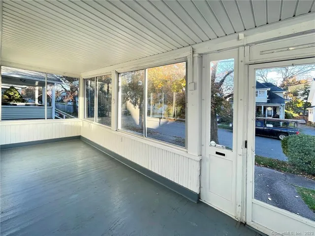 a view of a porch with furniture and floor to ceiling window