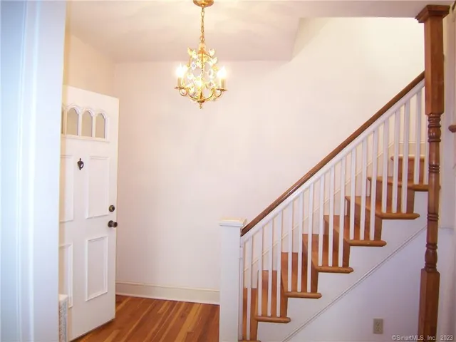 a view of a hallway with wooden floor and staircase