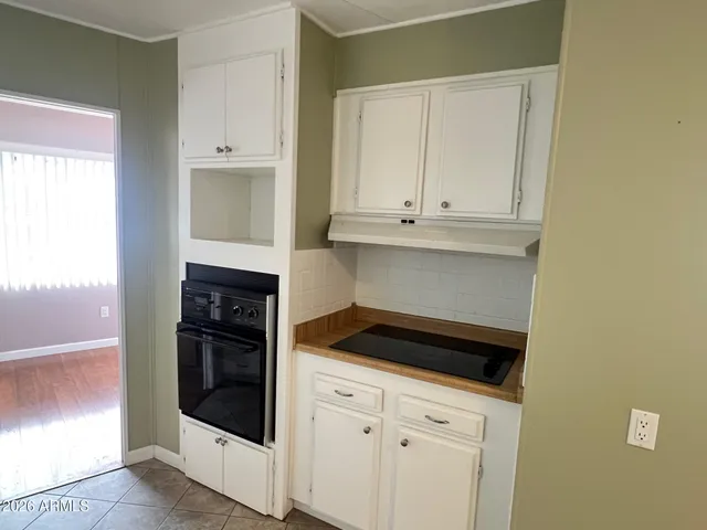 a kitchen with white cabinets and black appliances