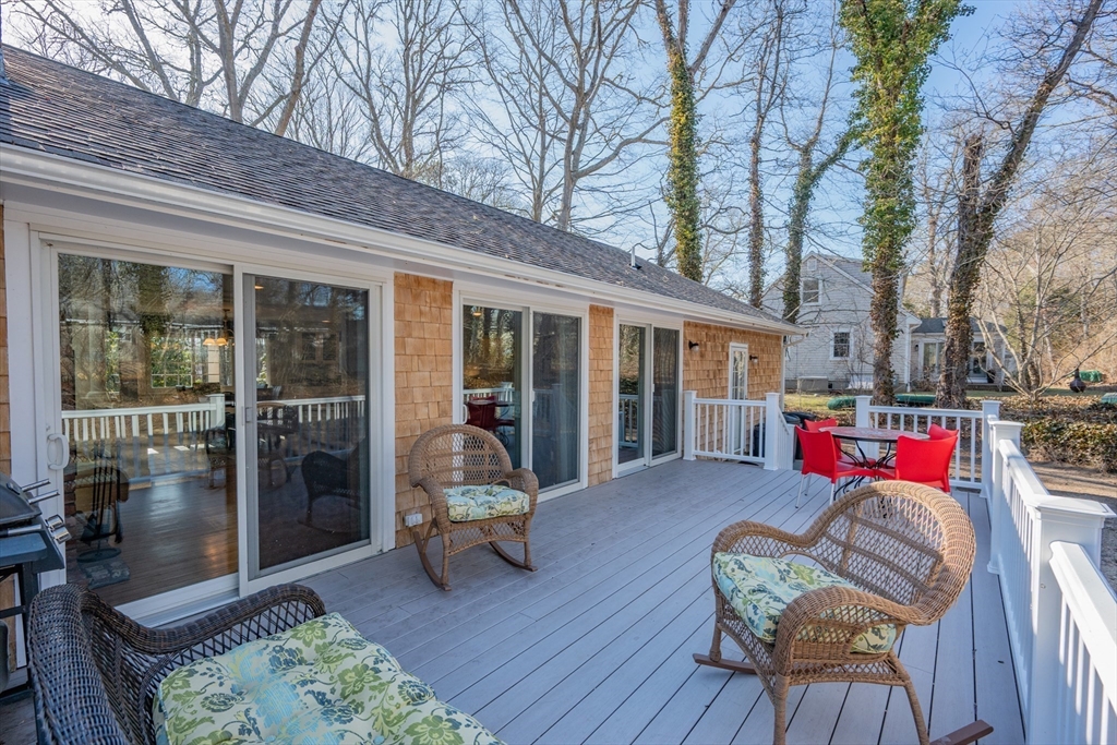 91 Holly Point Road Barnstable, MA 02632 - Photo 33 of 42 a view of a patio with couches table and chairs and wooden floor