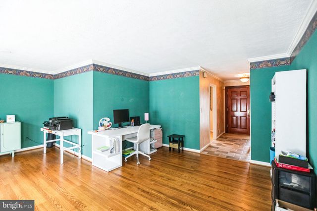 a living room with furniture a wooden floor and next to a dining room