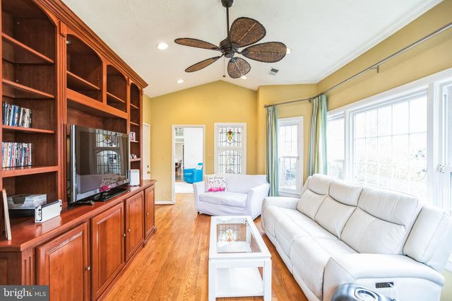 a living room with furniture a flat screen tv and a large window