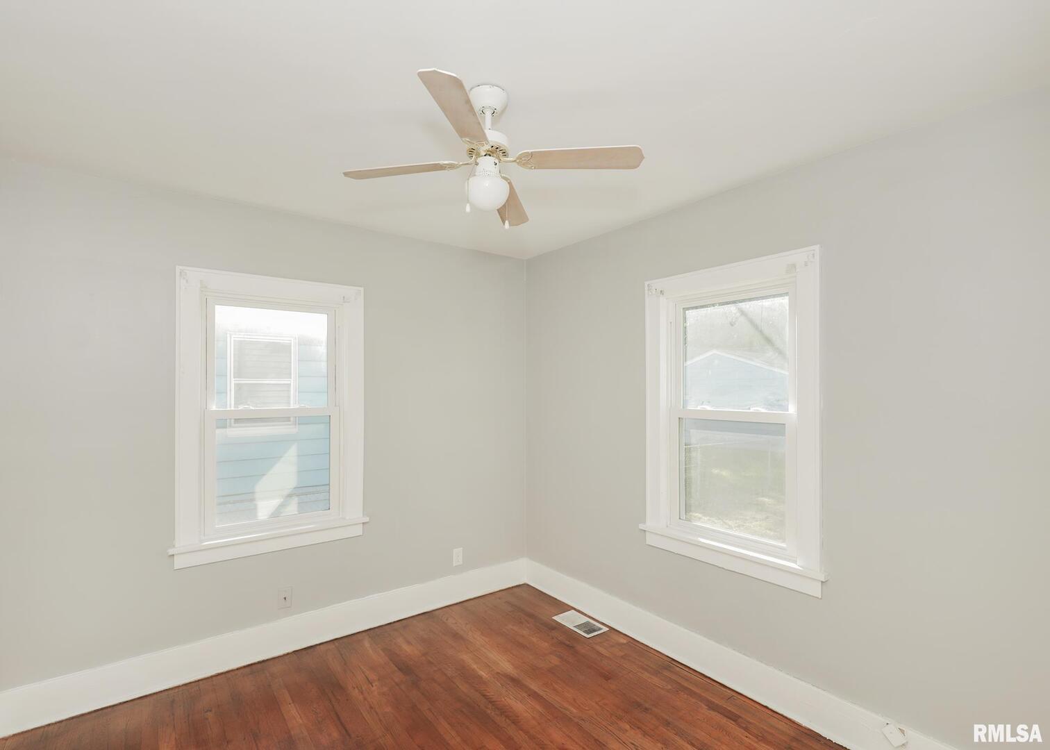 934 20th Avenue Rock Island, IL 61201 - Photo 12 of 26 an empty room with wooden floor ceiling fan and windows
