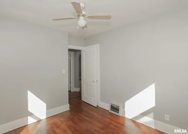 a view of an empty room with wooden floor