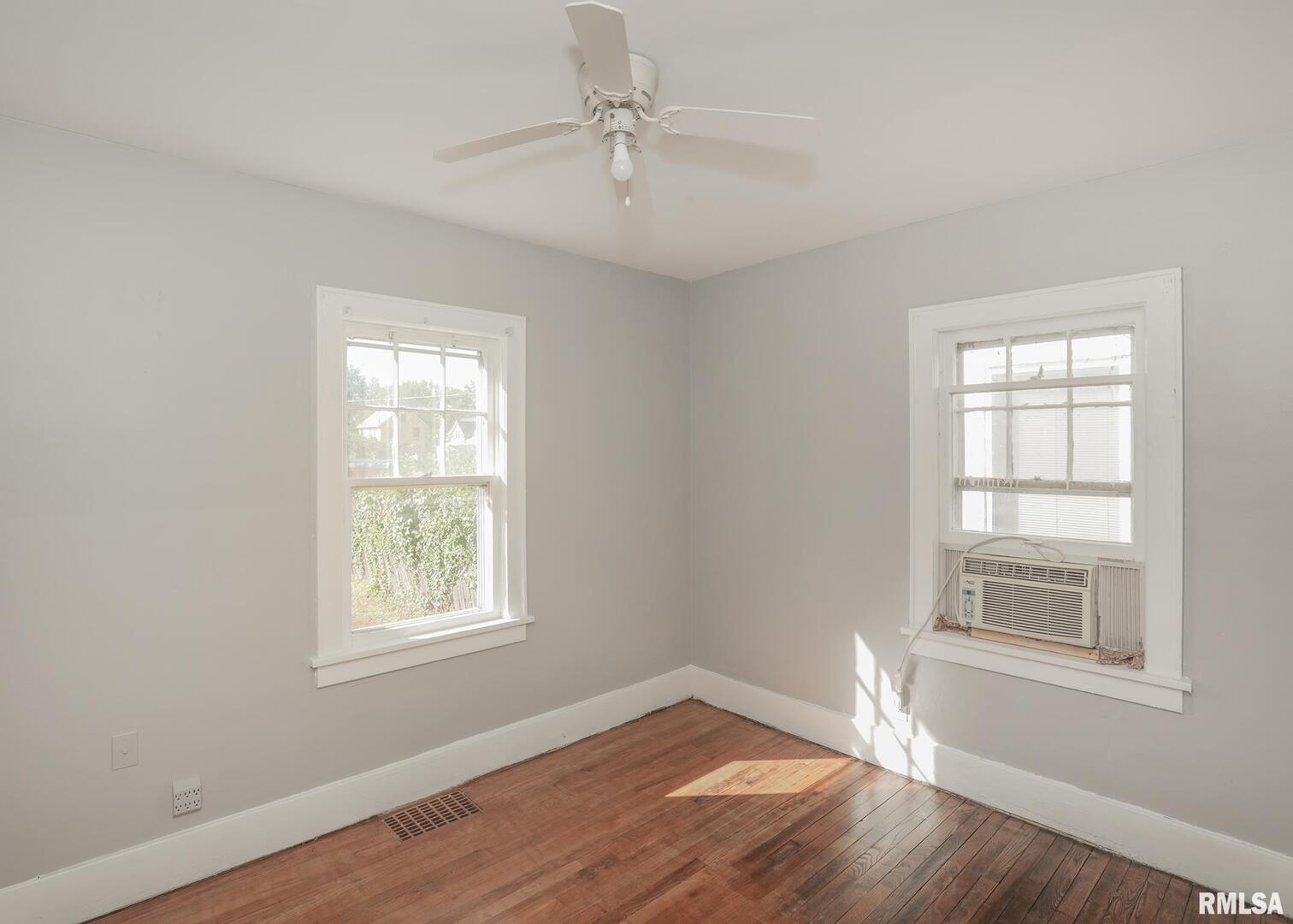 934 20th Avenue Rock Island, IL 61201 - Photo 15 of 26 an empty room with wooden floor ceiling fan and windows
