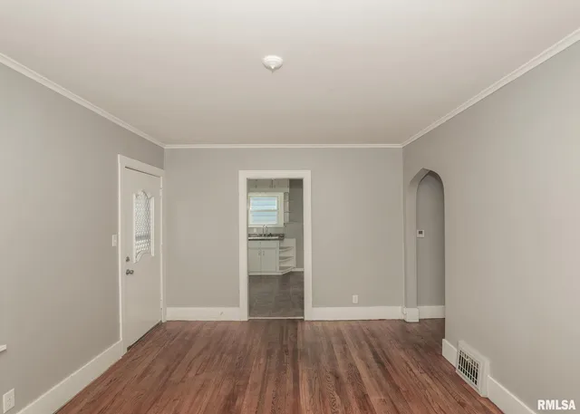 an empty room with wooden floor and closet
