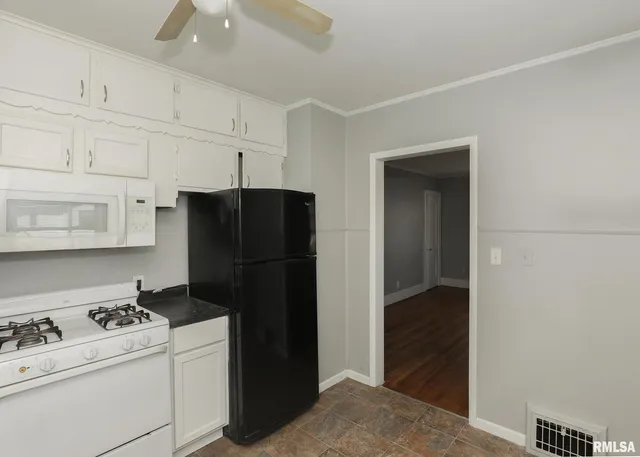a kitchen with a refrigerator and cabinets