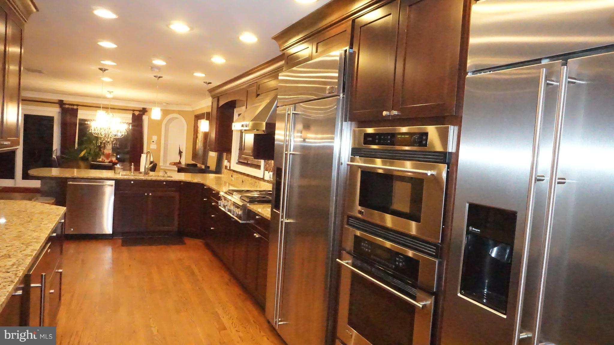9105 Cuckold Point Road Baltimore, MD 21219 - Photo 114 of 150 a kitchen with stainless steel appliances granite countertop a refrigerator a sink a stove and a wooden floors