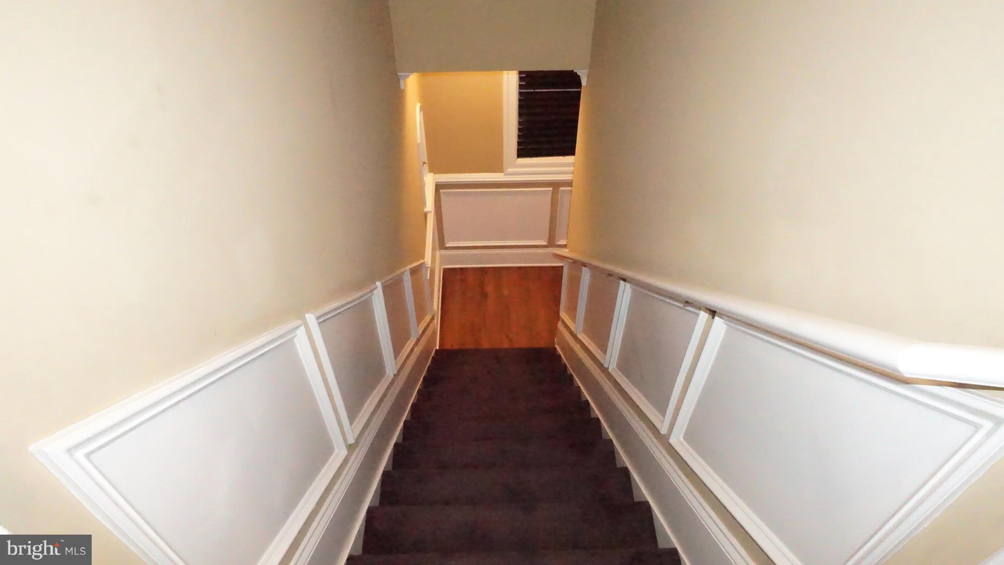 9105 Cuckold Point Road Baltimore, MD 21219 - Photo 42 of 150 a view of a hallway with wooden floor and staircase