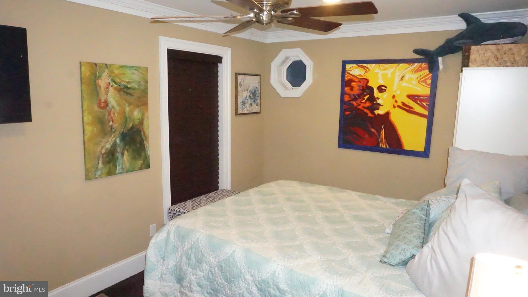 9105 Cuckold Point Road Baltimore, MD 21219 - Photo 84 of 150 a bedroom with a bed and a painting on the wall