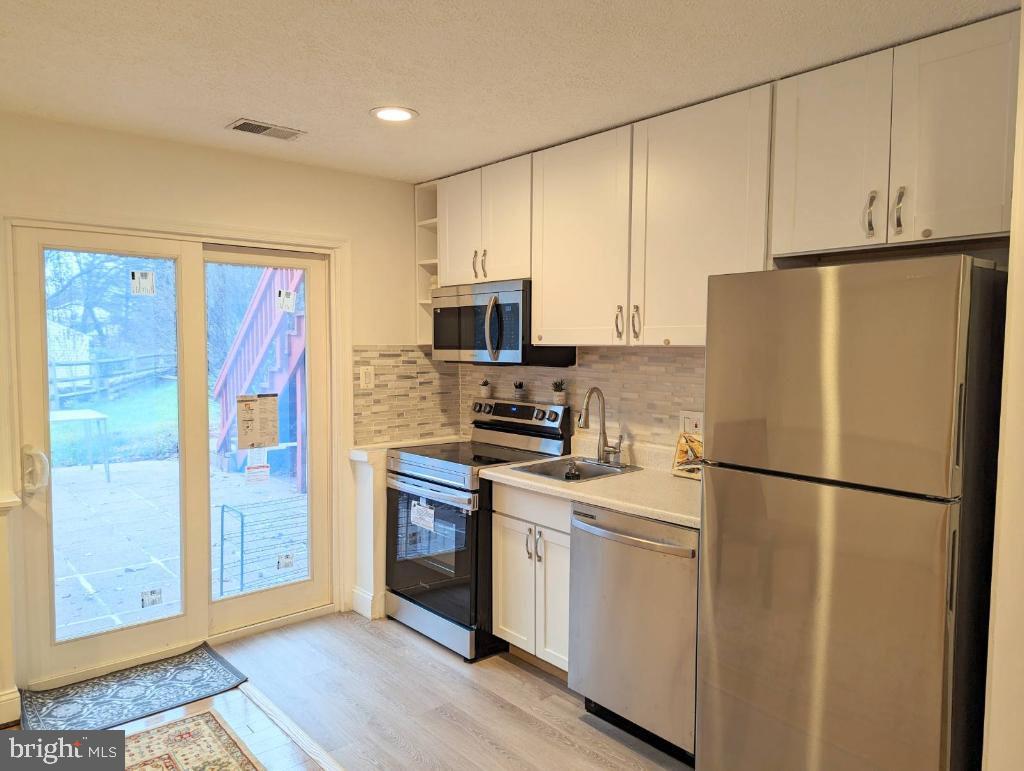 a white refrigerator freezer and a stove sitting inside of a kitchen