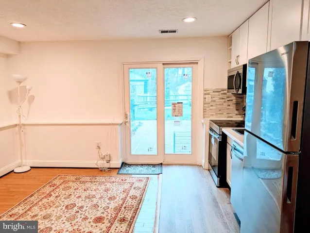 a view of a kitchen with a sink and refrigerator