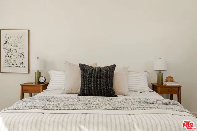 a spacious bedroom with a bed and painting on the wall