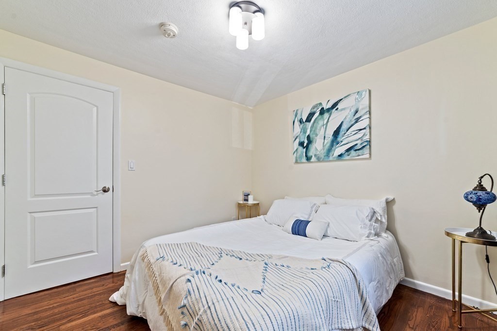 545 Potter Road Framingham, MA 01701 - Photo 11 of 42 a bedroom with a large bed and a chandelier