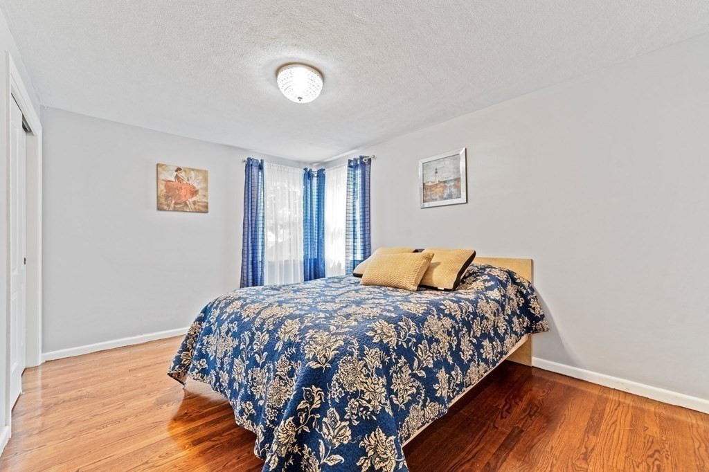 545 Potter Road Framingham, MA 01701 - Photo 12 of 42 a bedroom with a bed and wooden floor
