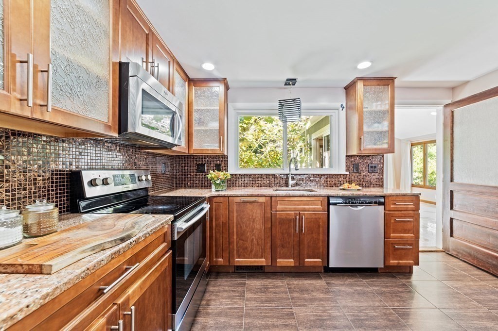 545 Potter Road Framingham, MA 01701 - Photo 20 of 42 a kitchen with stainless steel appliances granite countertop a stove a sink and a microwave