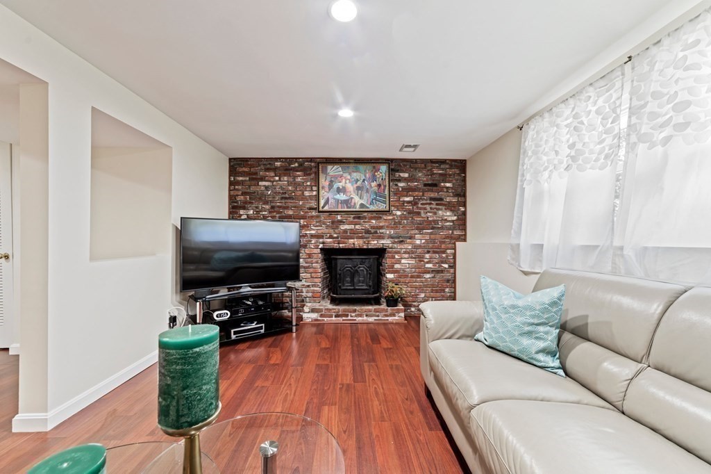 545 Potter Road Framingham, MA 01701 - Photo 29 of 42 a living room with furniture a fireplace and a flat screen tv