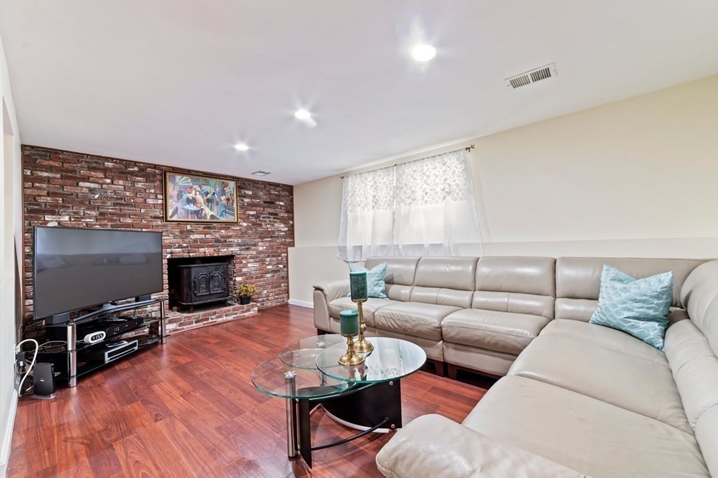 545 Potter Road Framingham, MA 01701 - Photo 9 of 42 a living room with furniture a fireplace and a flat screen tv