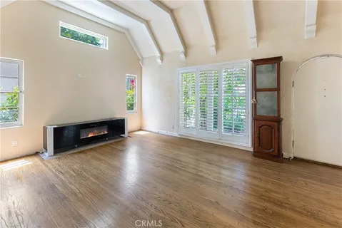 a view of a livingroom with wooden floor and a fireplace