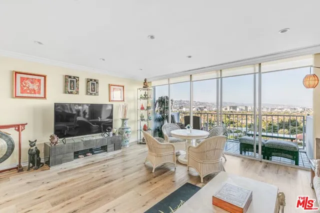 a living room with furniture a flat screen tv and a floor to ceiling window