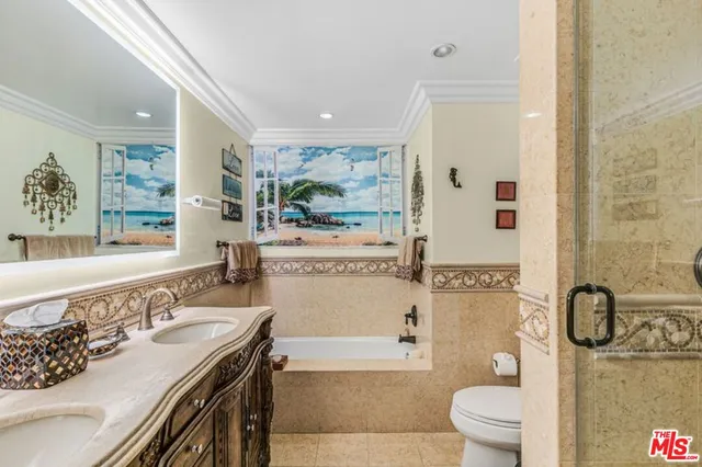 a bathroom with a granite countertop sink mirror vanity bathtub and a toilet
