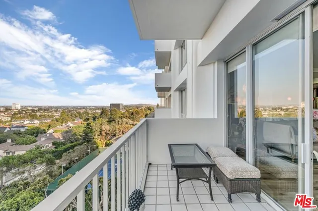 a view of a balcony with chair and city view