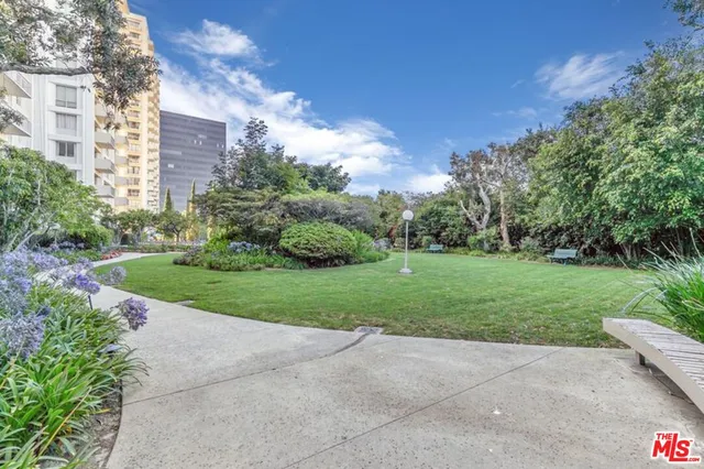 a view of a garden with large buildings