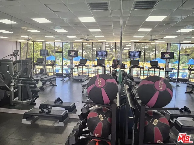 a room with gym equipment and a view of chandelier