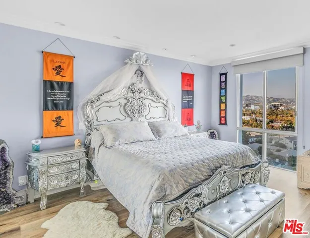 a bedroom with a bed and painting on the wall