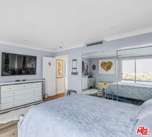 a spacious bedroom with a bed and a dresser in it