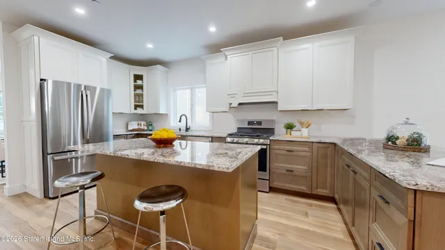 a kitchen with stainless steel appliances granite countertop a sink refrigerator and cabinets