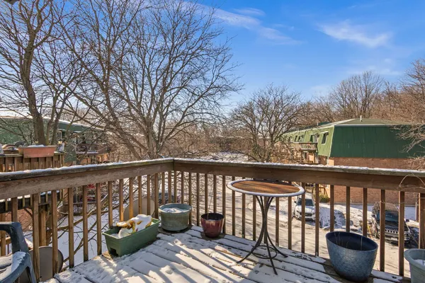 a balcony with wooden floor and outdoor seating