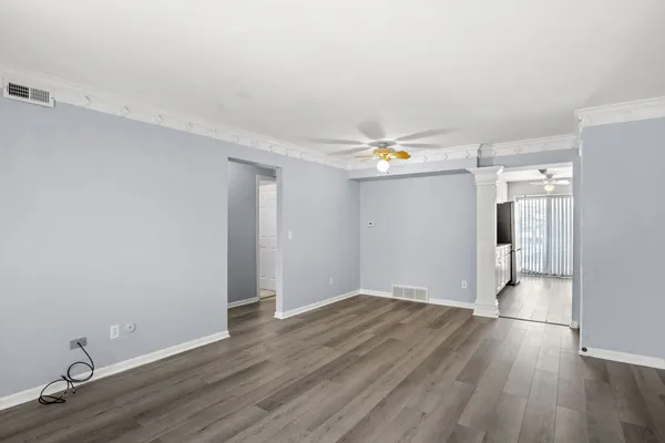 a view of empty room with wooden floor