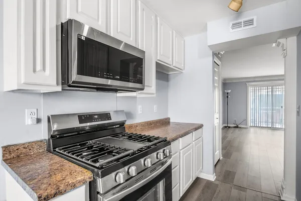 a kitchen with stainless steel appliances granite countertop a stove and a microwave